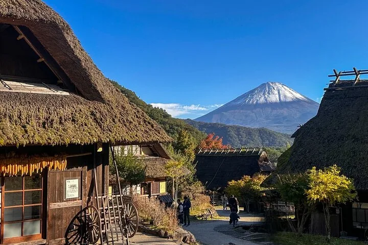 Traditional thatched-roof village with Mount Fuji visible in the clear background.